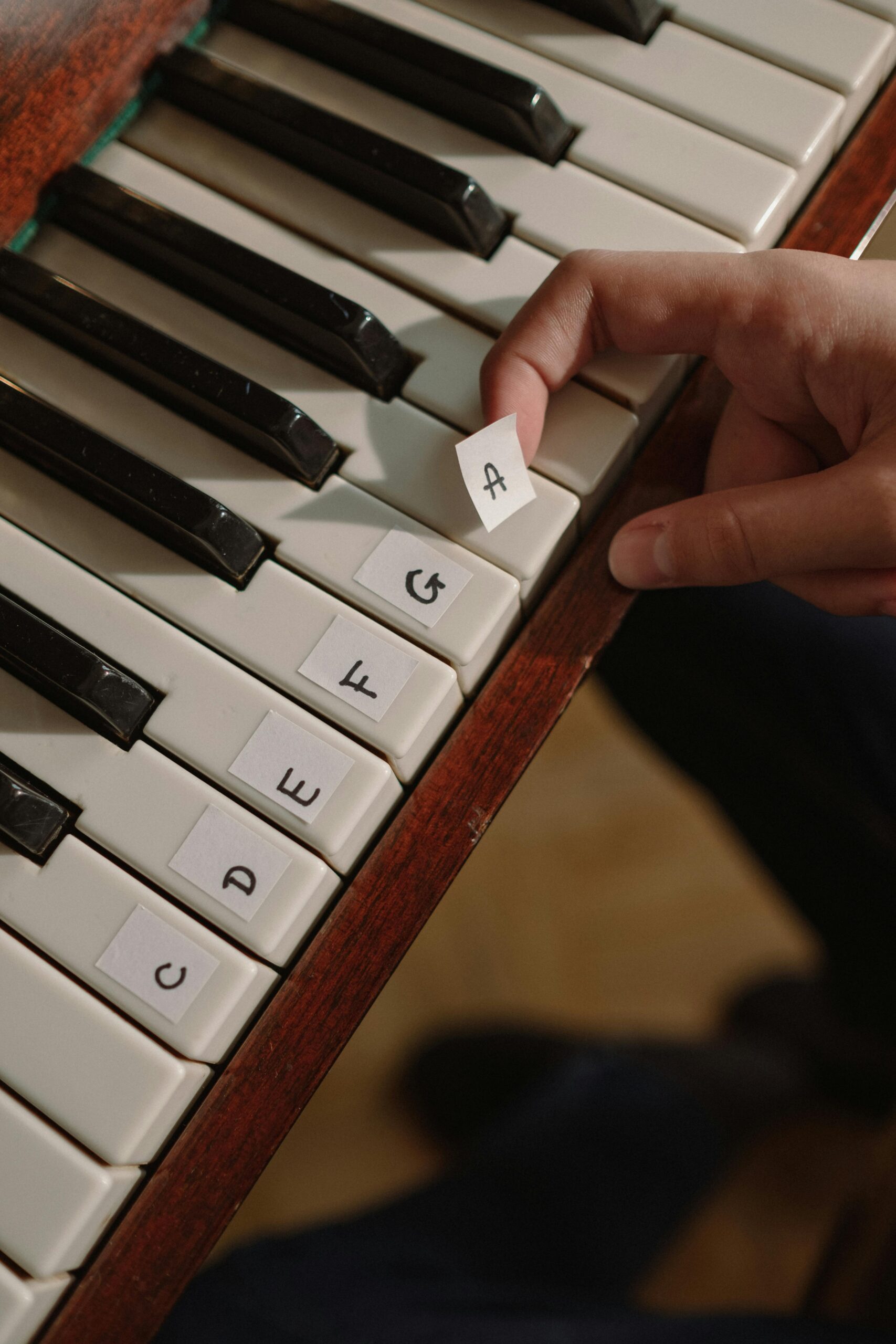 Close-up of fingers arranging letters on a piano keyboard.